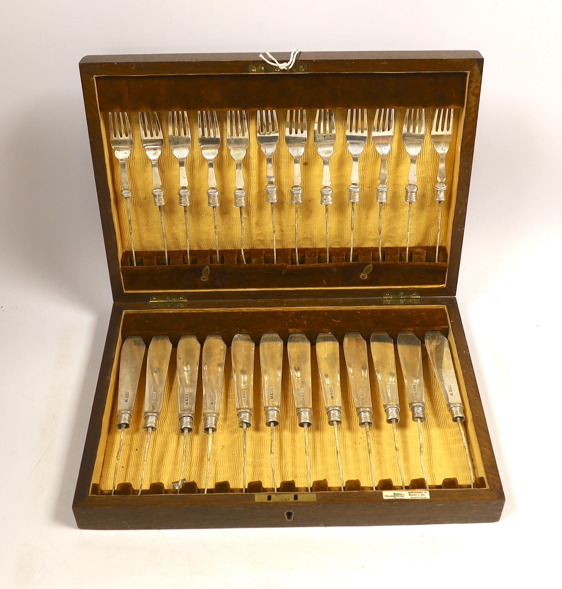 A set of twelve pairs of silver fish knife blades and fork tines, Walker & Hall, Sheffield 1933, in canteen (no handles), gross weight 24.6oz.